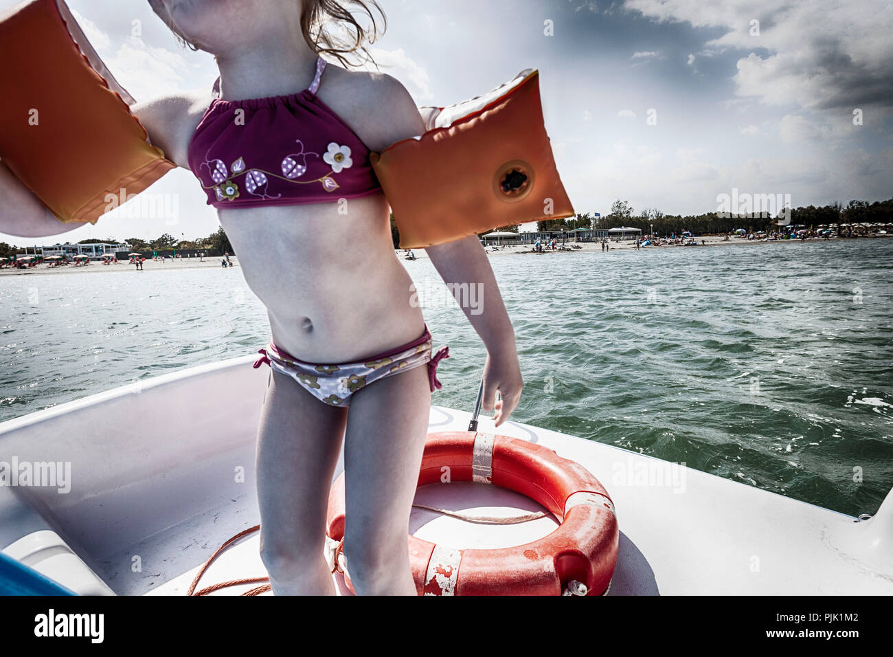Kleines Mädchen mit Wasser Flügel auf Boot Stockfoto