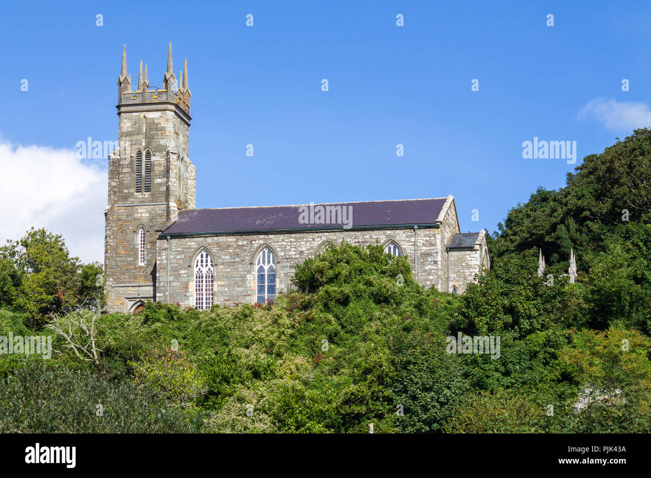 Dorfkirche von Bäumen umgeben in West Cork, Irland mit einem blauen Himmel. Stockfoto
