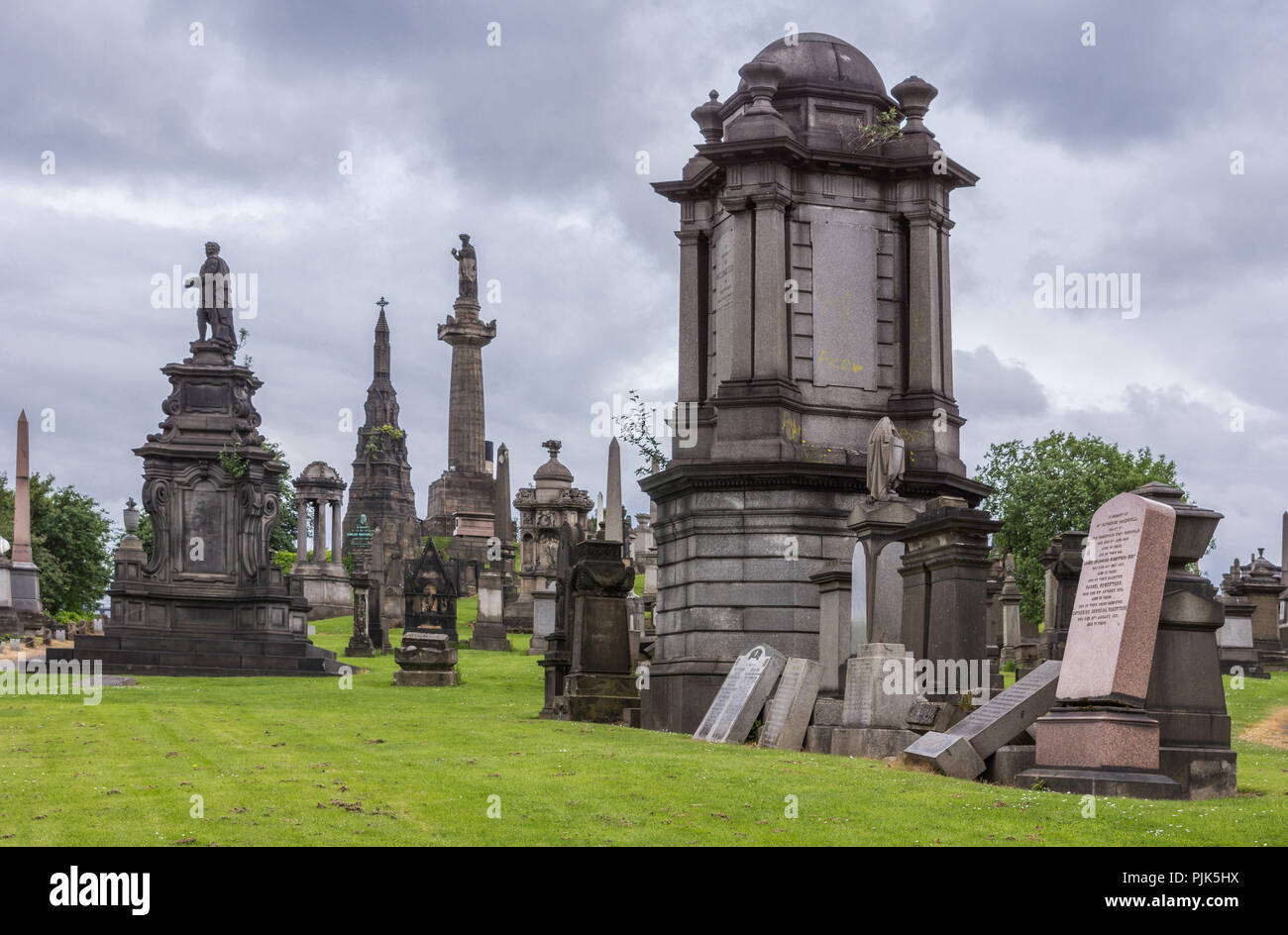 Glasgow, Schottland, Großbritannien, 17. Juni 2012: Nekropole. Gruppe von Großen und Kleinen memorial Braun geformten Stein Denkmäler mit John Knox Obelisk unter schweren cl Stockfoto