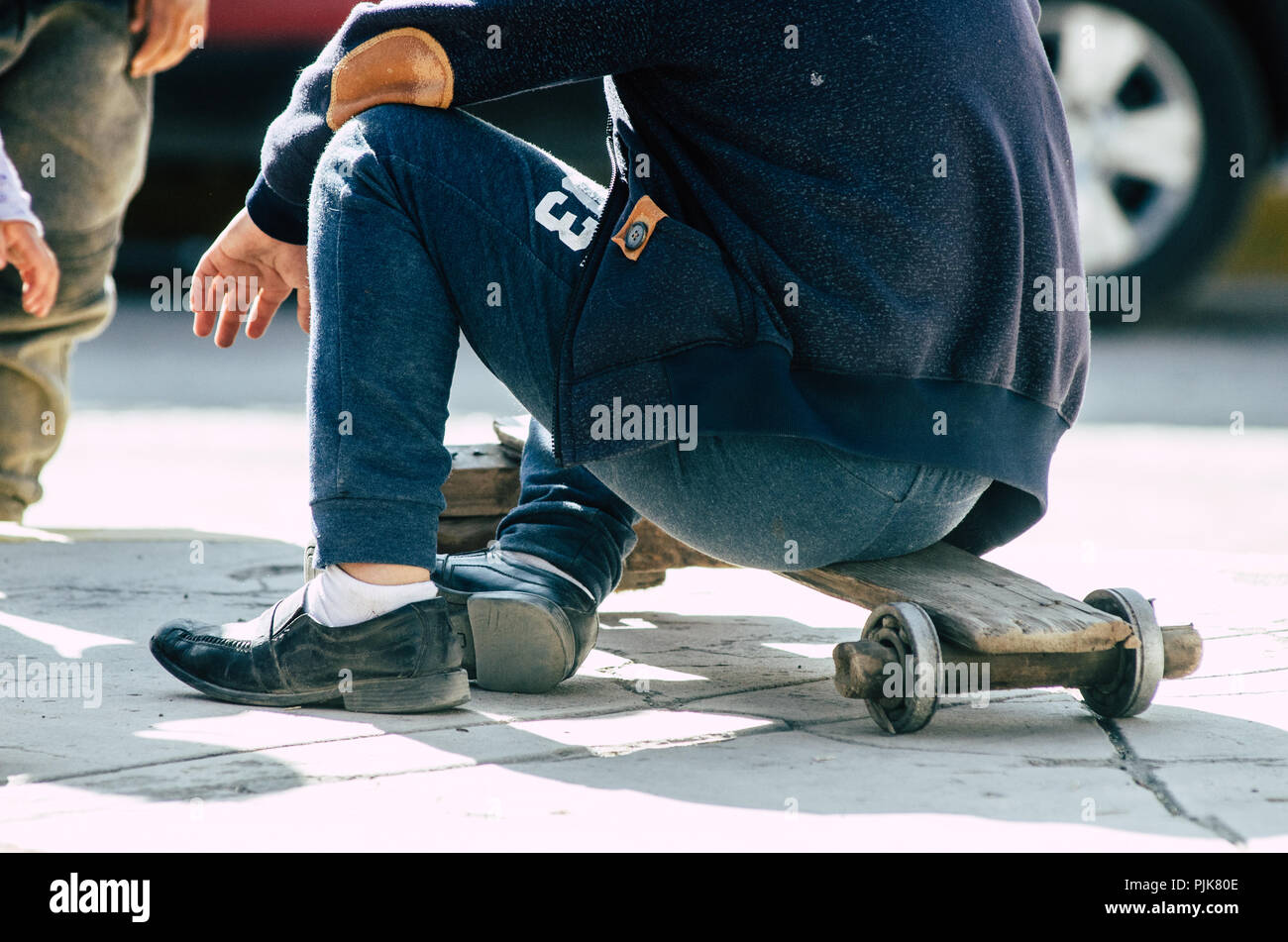 Kinder spielen auf der Straße mit einem Handwerker skateboard an einem sonnigen Tag Stockfoto