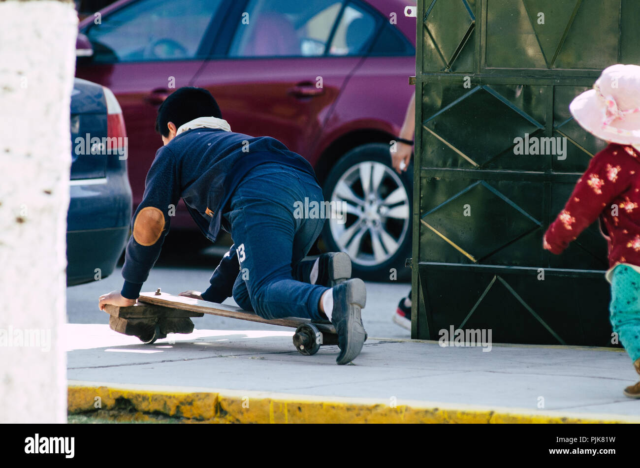 Kinder spielen auf der Straße mit einem Handwerker skateboard an einem sonnigen Tag Stockfoto