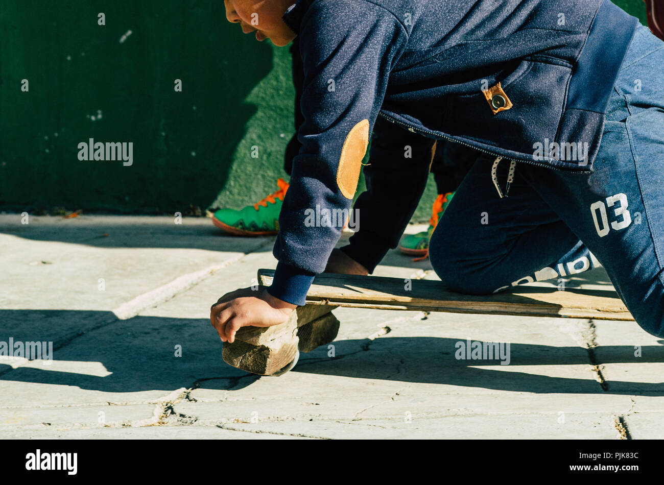 Kinder spielen auf der Straße mit einem Handwerker skateboard an einem sonnigen Tag Stockfoto