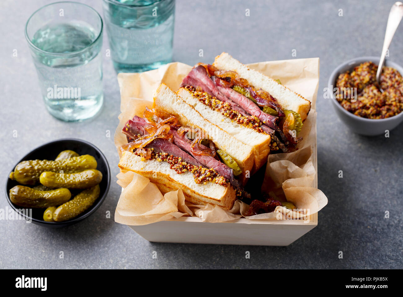 Sandwich mit Roastbeef in Holzkiste. Grauen Stein Hintergrund. Nahaufnahme Stockfoto