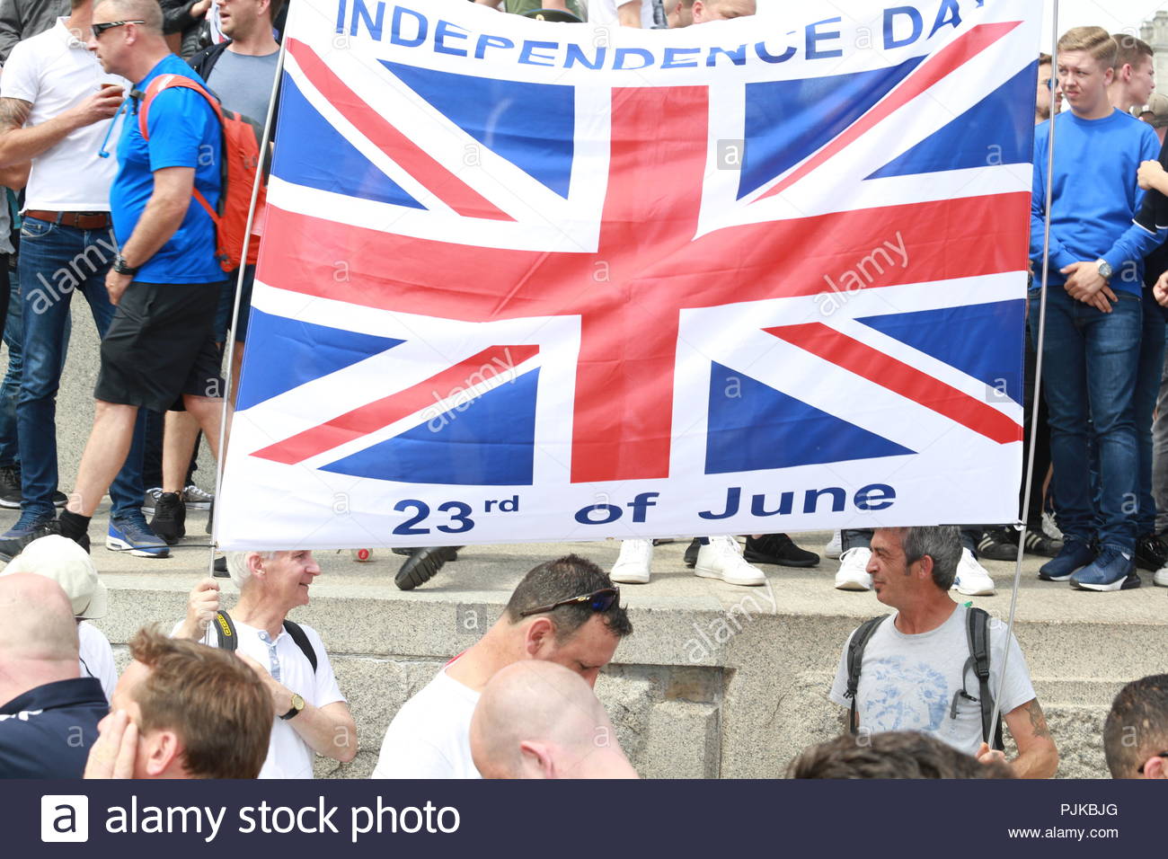 Uk Independence Day Flagge gehalten aloft von Tommy Robinson Unterstützer der Bestätigung ihre Unterstützung für Brexit Stockfoto