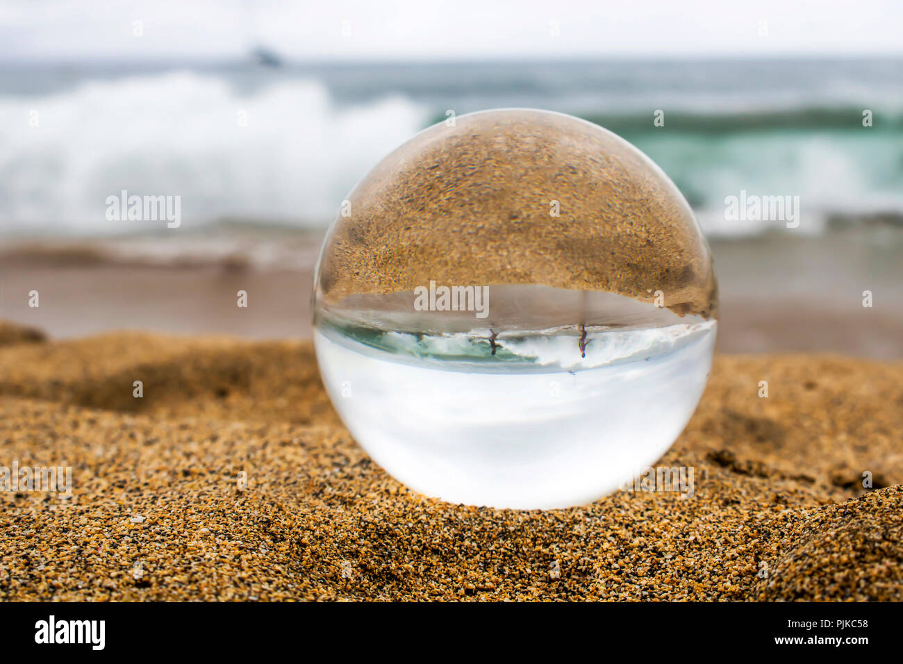 Sand und brechende Welle mit Kindern durch Glas oder Crystal Ball  Stockfotografie - Alamy
