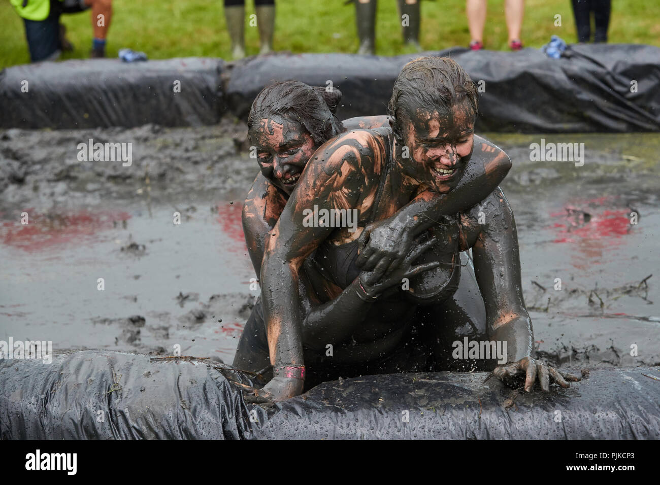 Zwei Frauen mud Wrestling mit im Tiefland Spiele, Thorney, Somerset, England Stockfoto