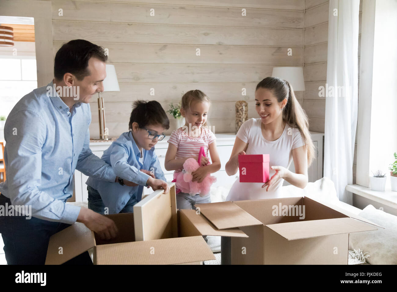 Glückliche Familie auspacken Kartons zum neuen Haus bewegen Stockfoto