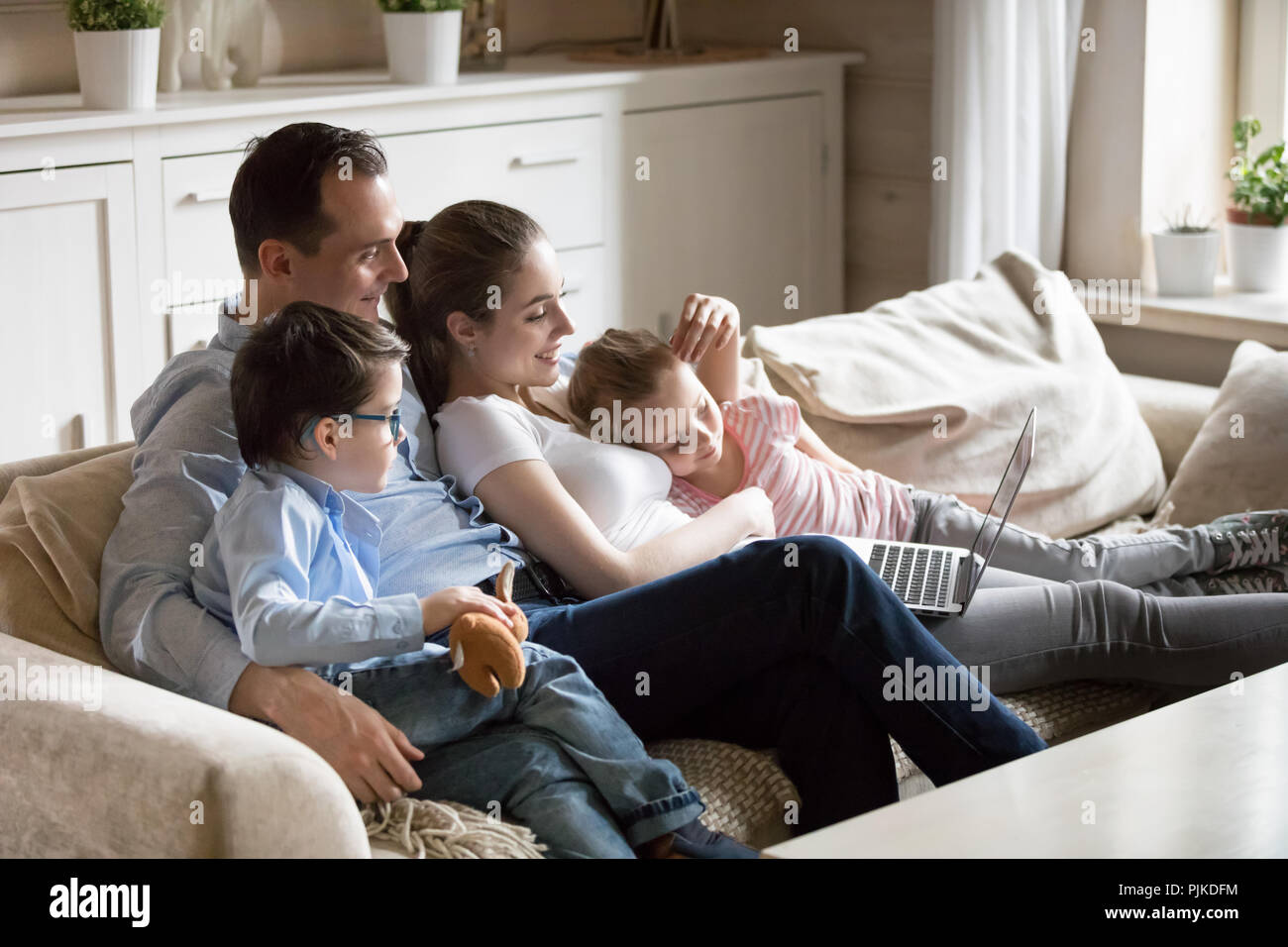 Eltern Kuscheln mit Kindern beobachten kid Video mit Laptop Stockfoto