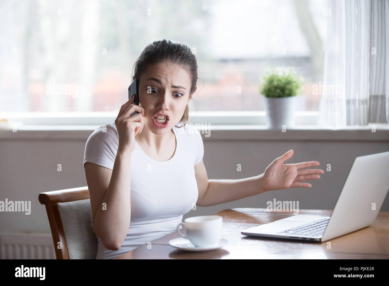 Wütende Frau streiten während Telefonieren auf Zelle Stockfoto