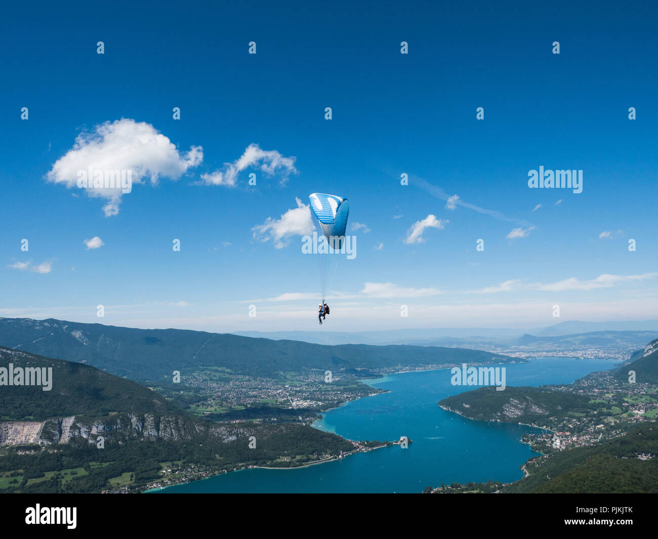 Gleitschirm über den Lac d'Annecy scheint die Wolken berühren Stockfoto