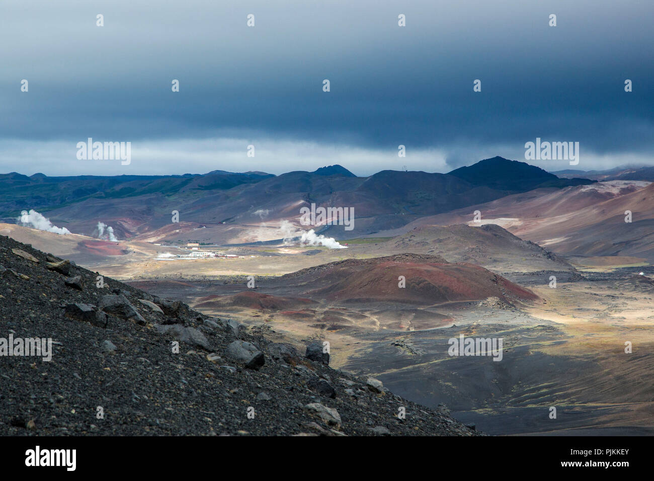 Island, dramatische Beleuchtung über Krafla Vulkan, weiße Wolken der Geothermie, schwarze Wolken über braune Berge in der Sonne Stockfoto