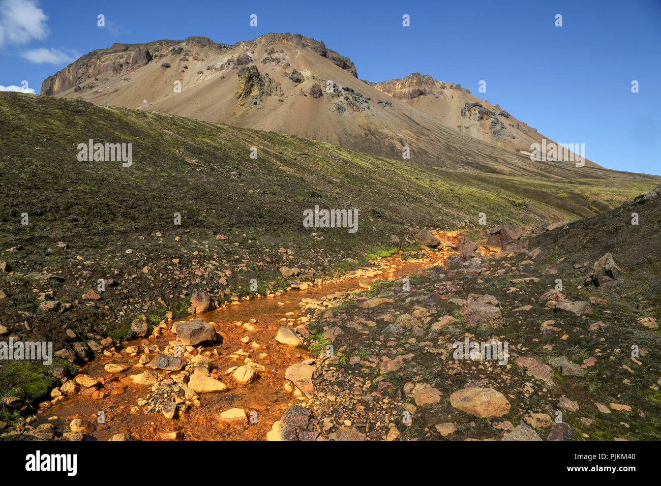Island, Orange Brook, Mineral, grünen Hügel Berg im Hintergrund Stockfoto