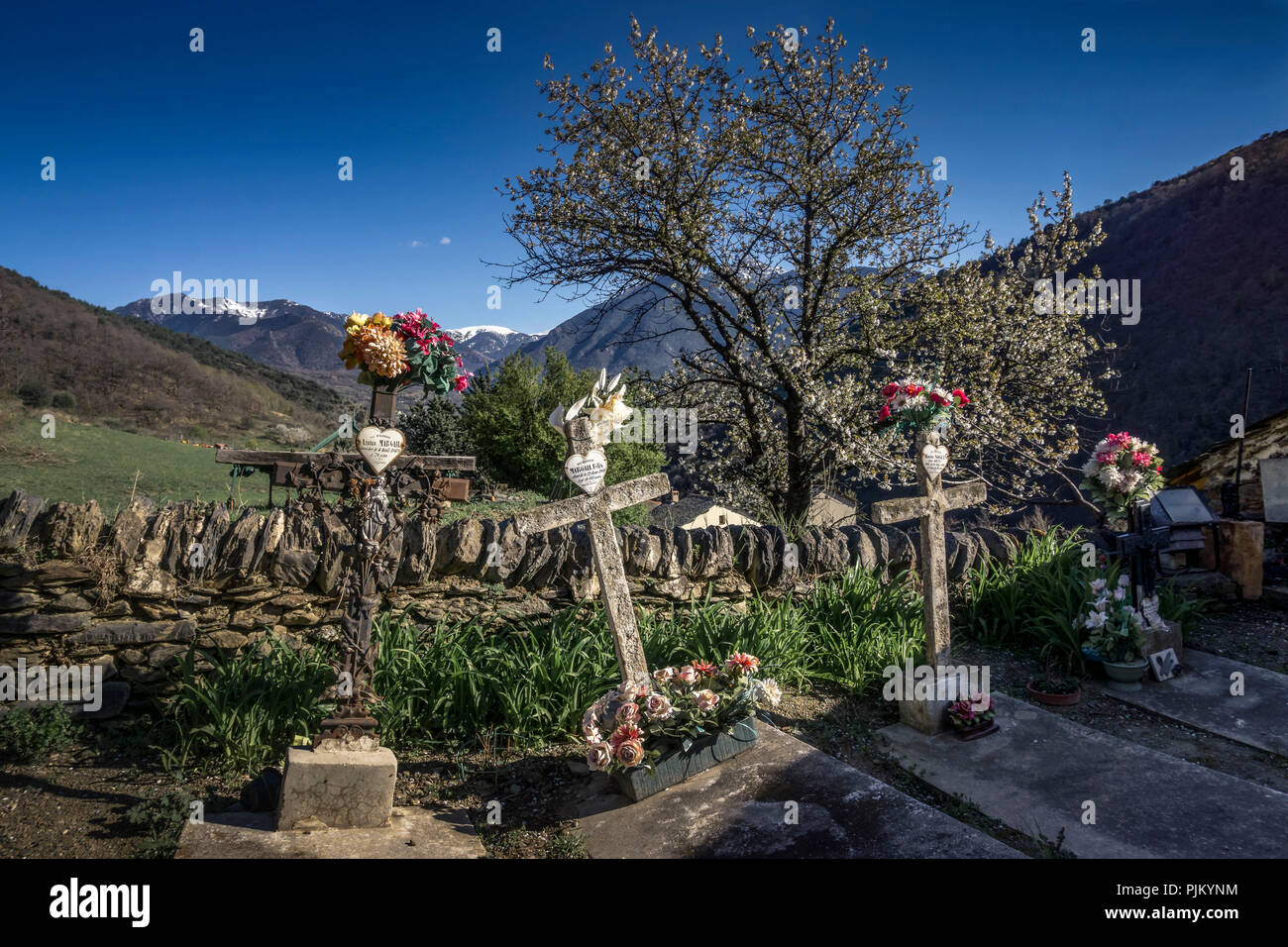 Friedhof im Frühjahr Église Notre-Dame in Evol, plus beaux villages de France, Stockfoto