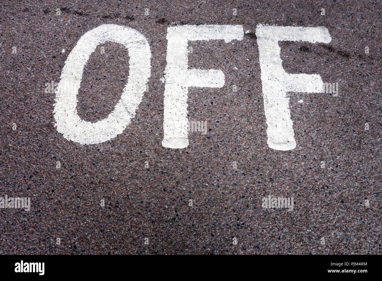 Das Wort "Off" (Aus) auf Fahrbahn im Parkhaus geschrieben Stockfoto
