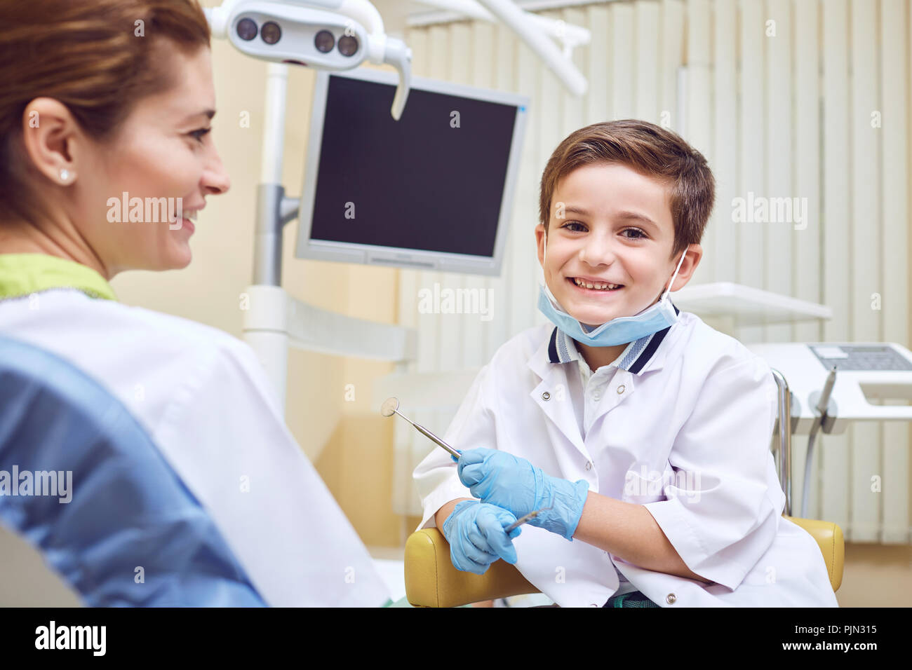Ein Junge ist ein Zahnarzt mit einem Patienten in einer Zahnklinik Stockfoto