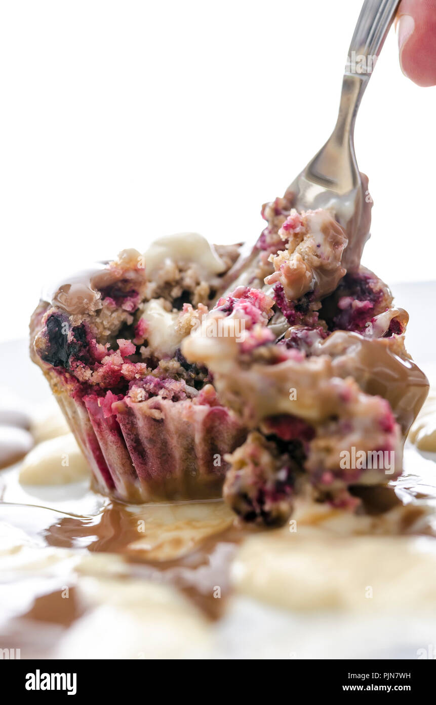 Das Essen einer berry Muffin mit einer Gabel. Mit weißem Hintergrund. Stockfoto