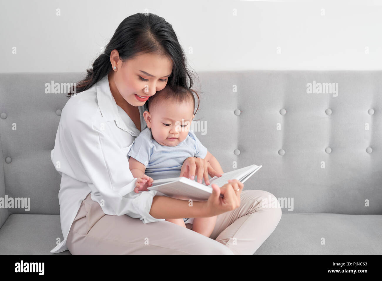 Jungen asiatischen Mutter Lesung Buch zum Baby. Süßer Moment. Stockfoto