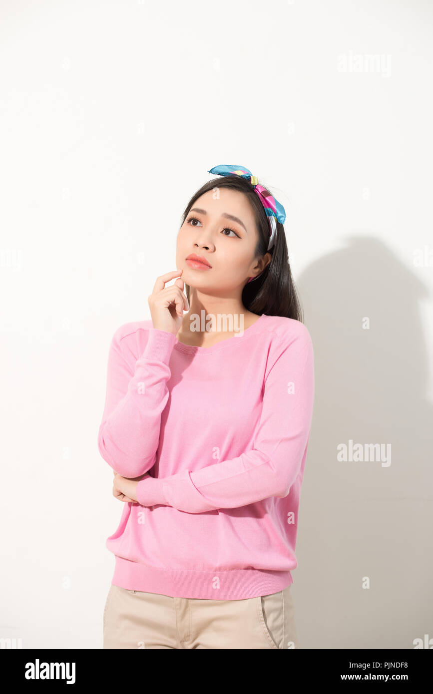 Porträt eines nachdenklichen jungen asiatischen Frau, die an der Kopie Raum suchen mit Hand auf ihr Kinn auf weißem Hintergrund Stockfoto