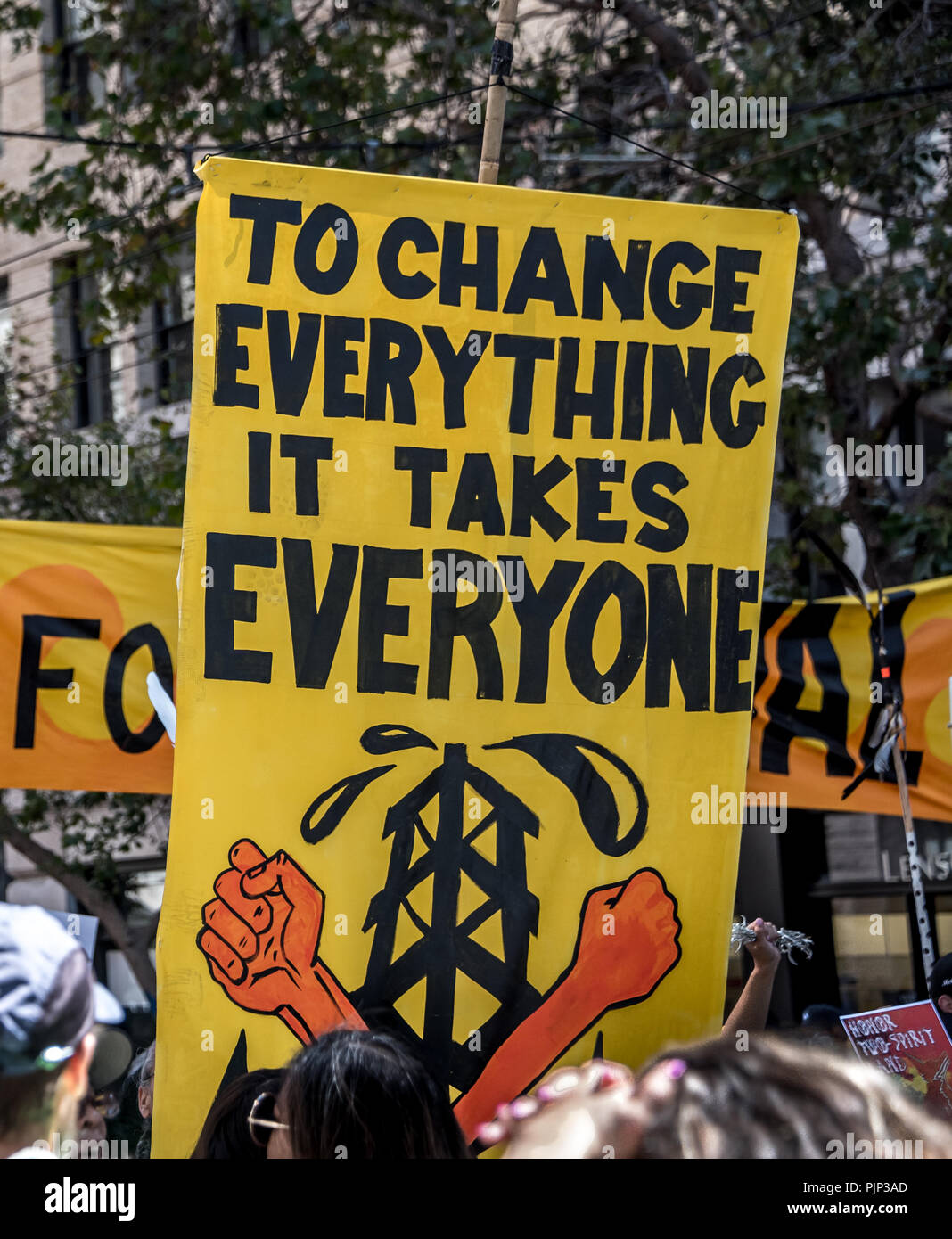 San Francisco, Kalifornien, USA. 8. September 2018. Tausende versammeln sich in San Francisco im Aufstieg für Klima Rally und März im Vorfeld der globalen Klimapolitik Gipfel es September 12. bis 14. stattfinden. Ein Zeichen statt über die Masse liest, zu ändern" alles, was es braucht alle" mit den Fäusten vor einem Turm. Shelly Rivoli/Alamy leben Nachrichten Stockfoto