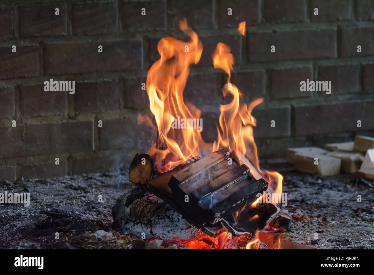 Glühende Holz Brennen log in der klaren Brand Nahaufnahme. Atmosphärischen Hintergrund mit Flamme der Lagerfeuer. Schönes Bild von der Brand von innen mit c Stockfoto