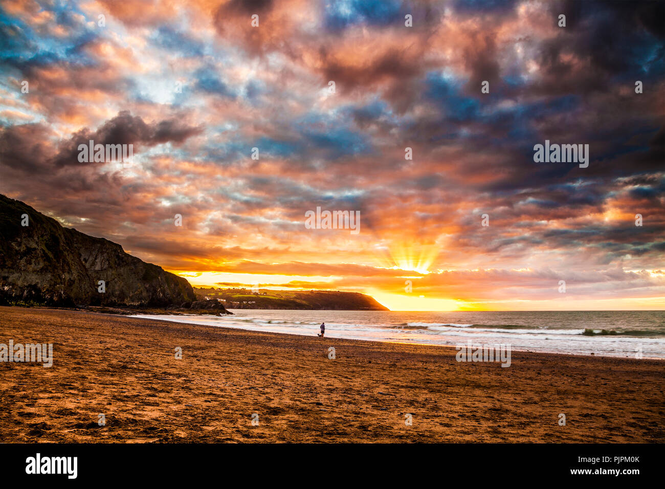 Sonnenuntergang über dem Strand von Tresaith, Ceredigion, Wales, in Richtung Aberporth. Stockfoto