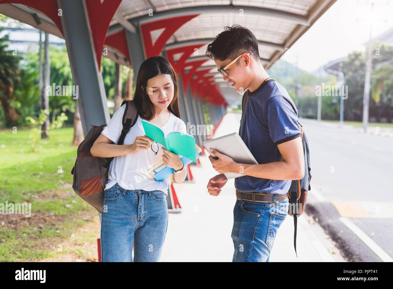 Zwei Asiatische junge Hochschule die Menschen über das Lesen Buch und mit Laptop für Suche diskutieren und Wissen lernen. Bildung und Freundschaft Konzept. Happin Stockfoto