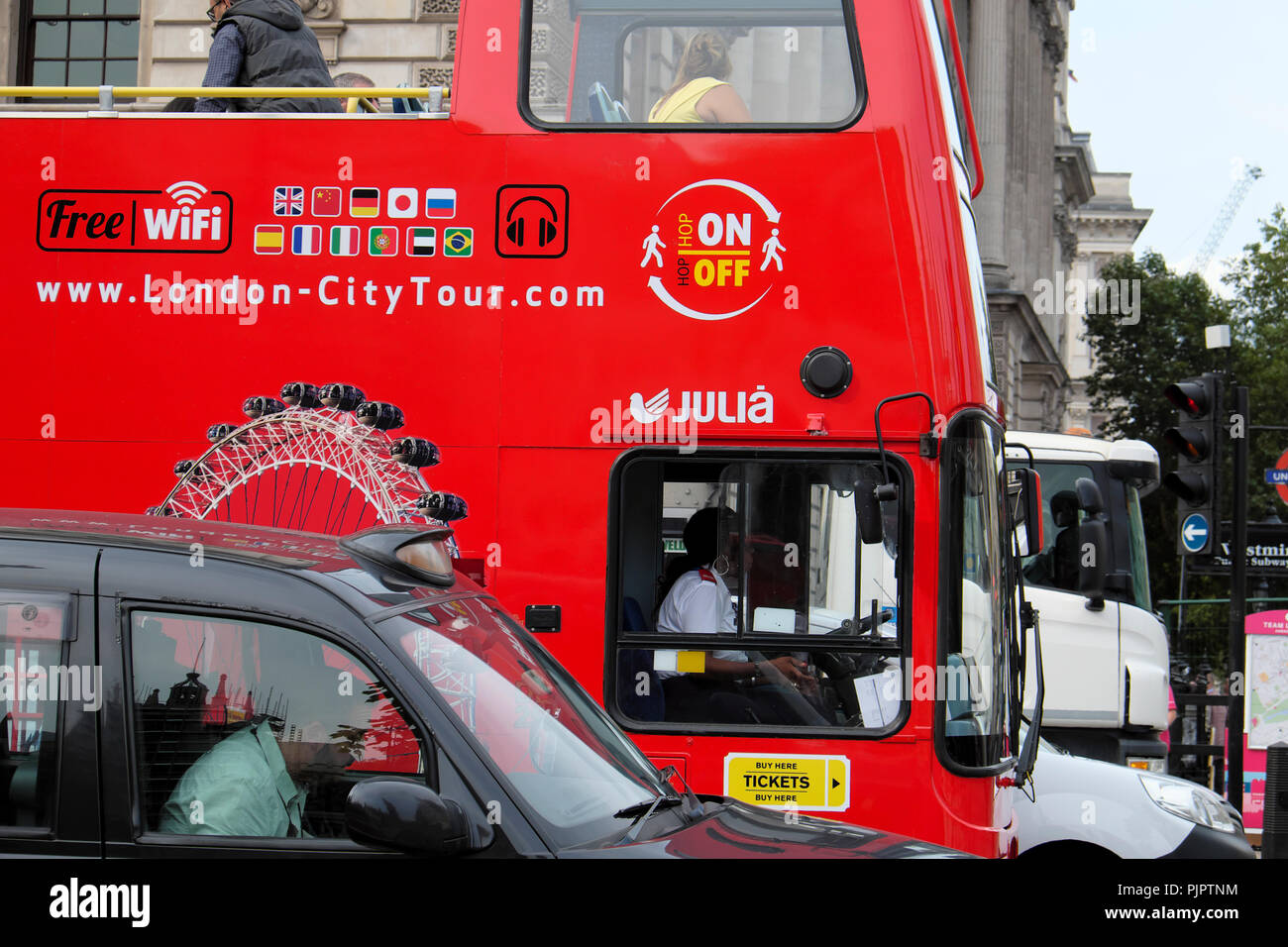 Rote Doppeldecker Hop on-Hop off-Tour Bus und Fahrer in Parliament Square Verkehr in Westminster London UK KATHY DEWITT klemmt Stockfoto