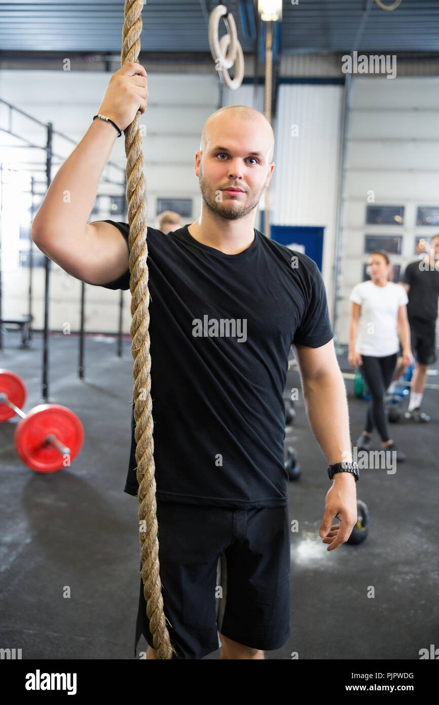 Zuversichtlich männlichen Athleten Holding Fitnessraum Seil in Health Club Stockfoto