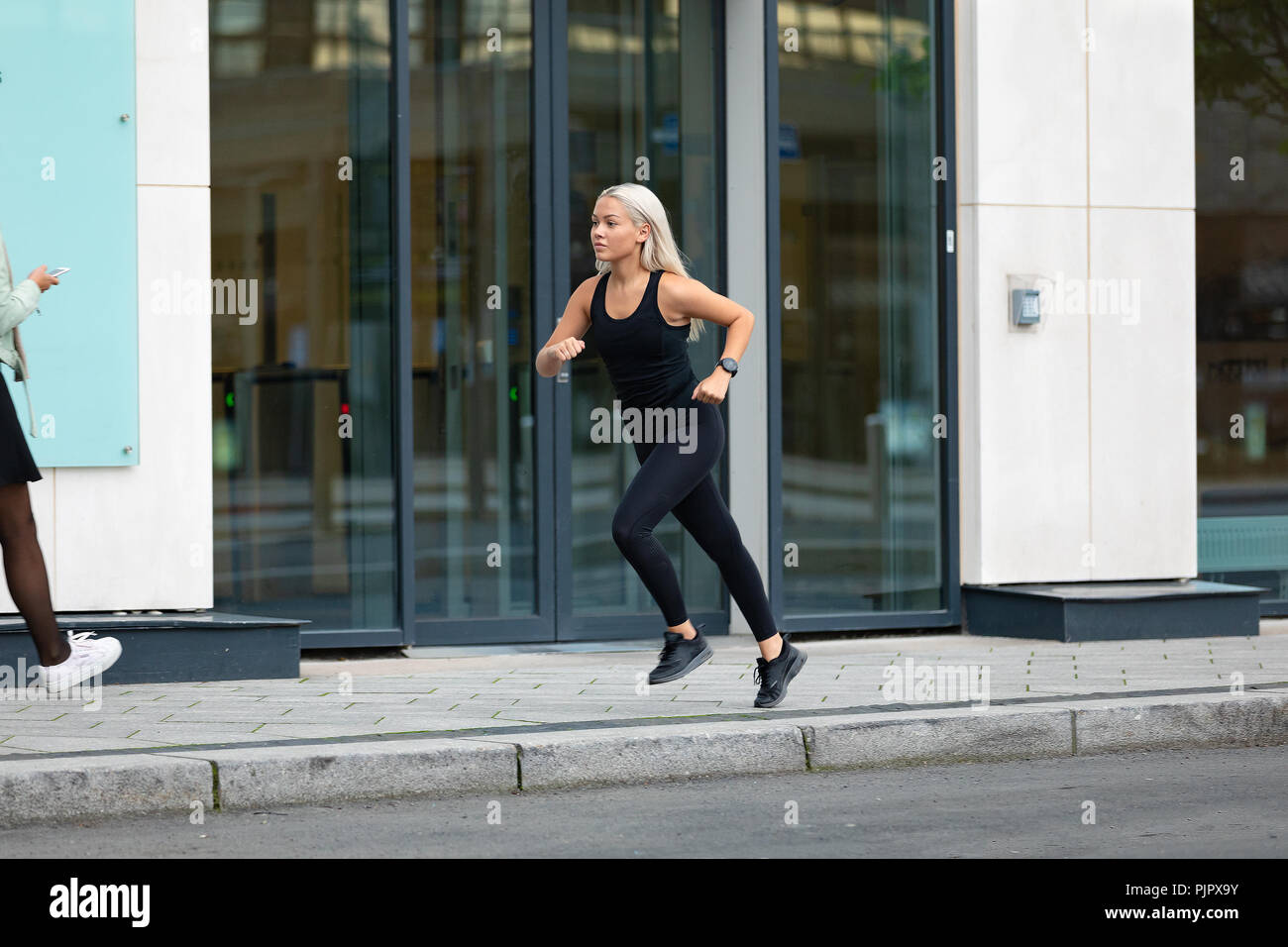 Seitenansicht der sportlichen Frau schnell den Betrieb im minimalistischen städtische Umwelt Stockfoto