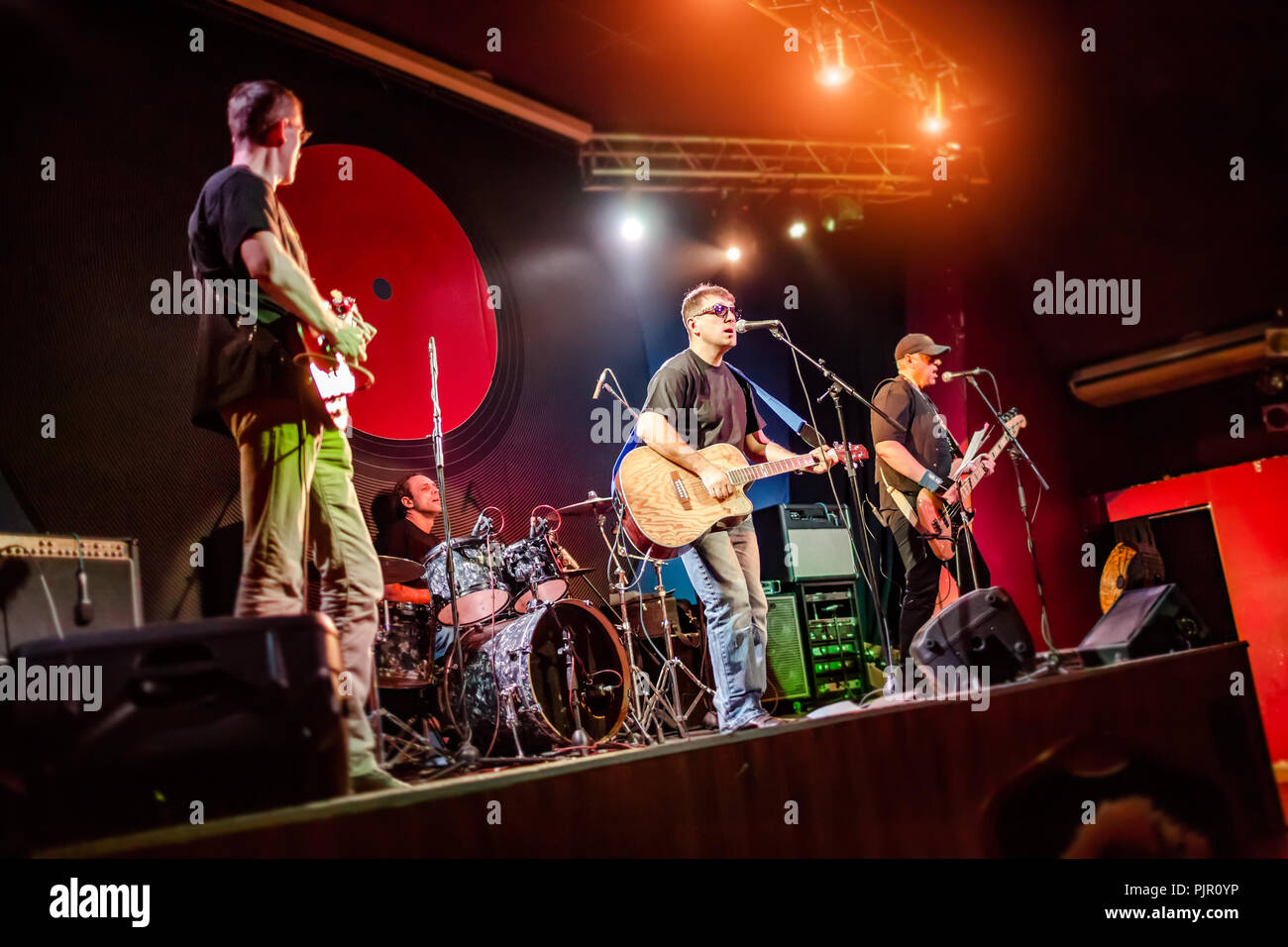 Band auf der Bühne, Rock Konzert in einem Nachtclub. Authentische Aufnahmen mit hoher ISO-Empfindlichkeit in schwierigen Lichtverhältnissen. Ein wenig Getreide und Stockfoto