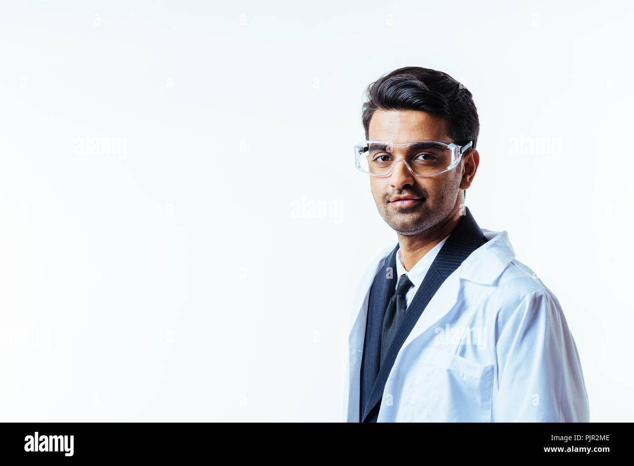 Porträt einer ernster Mann in Anzug, Laborkittel und Schutzbrille auf weißem studio Hintergrund isoliert Stockfoto