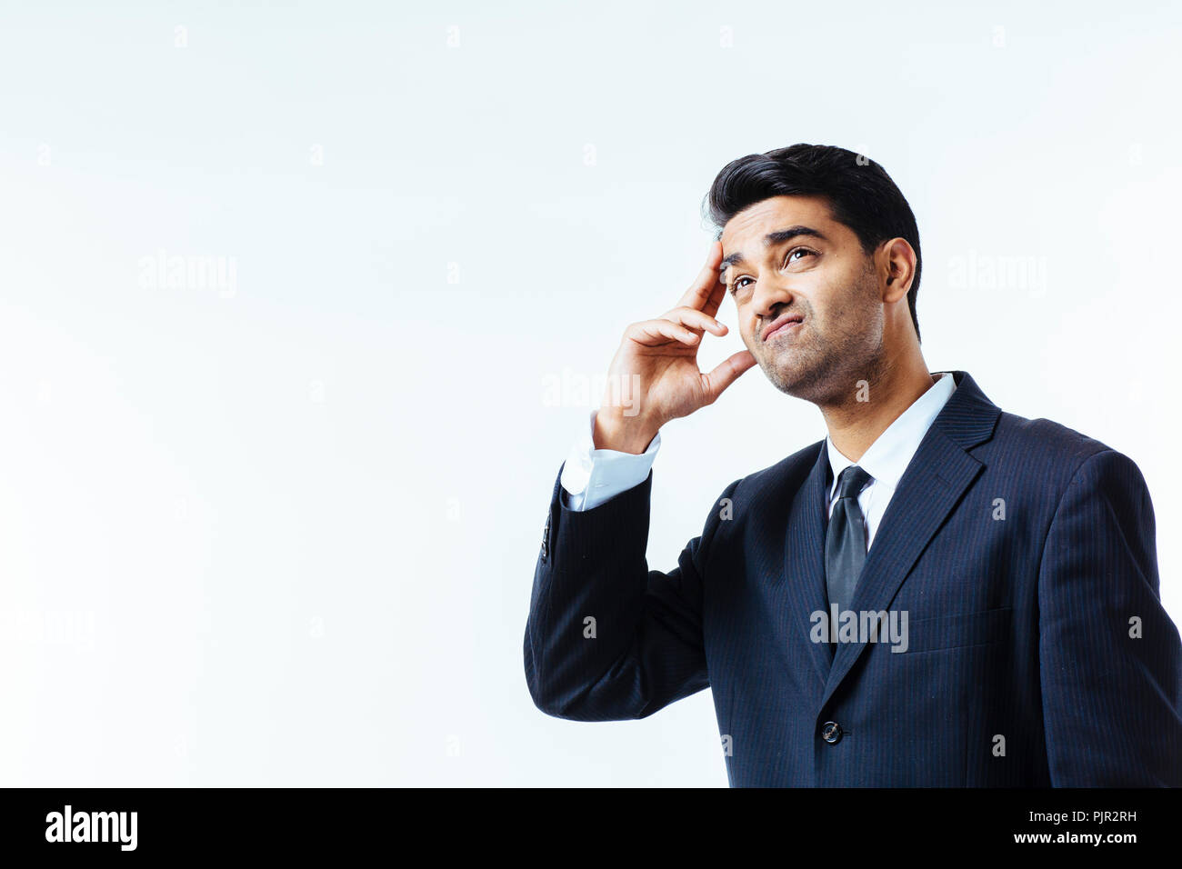 Porträt einer stattlichen Geschäftsmann seinen Kopf in Unglauben, in Schmerzen oder Meditieren, auf weißem Hintergrund Stockfoto
