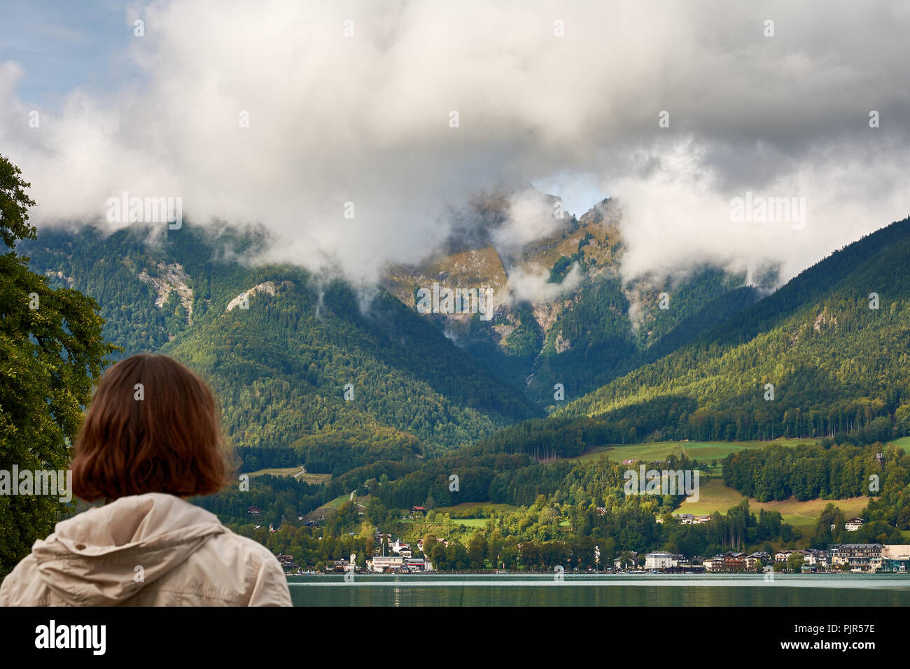Blick auf den See in der Nähe von St. Wolfgang mit einer Frau an der Alpen im Hintergrund suchen, Unter einem blauen Himmel mit Wolken an einem sonnigen Tag Stockfoto