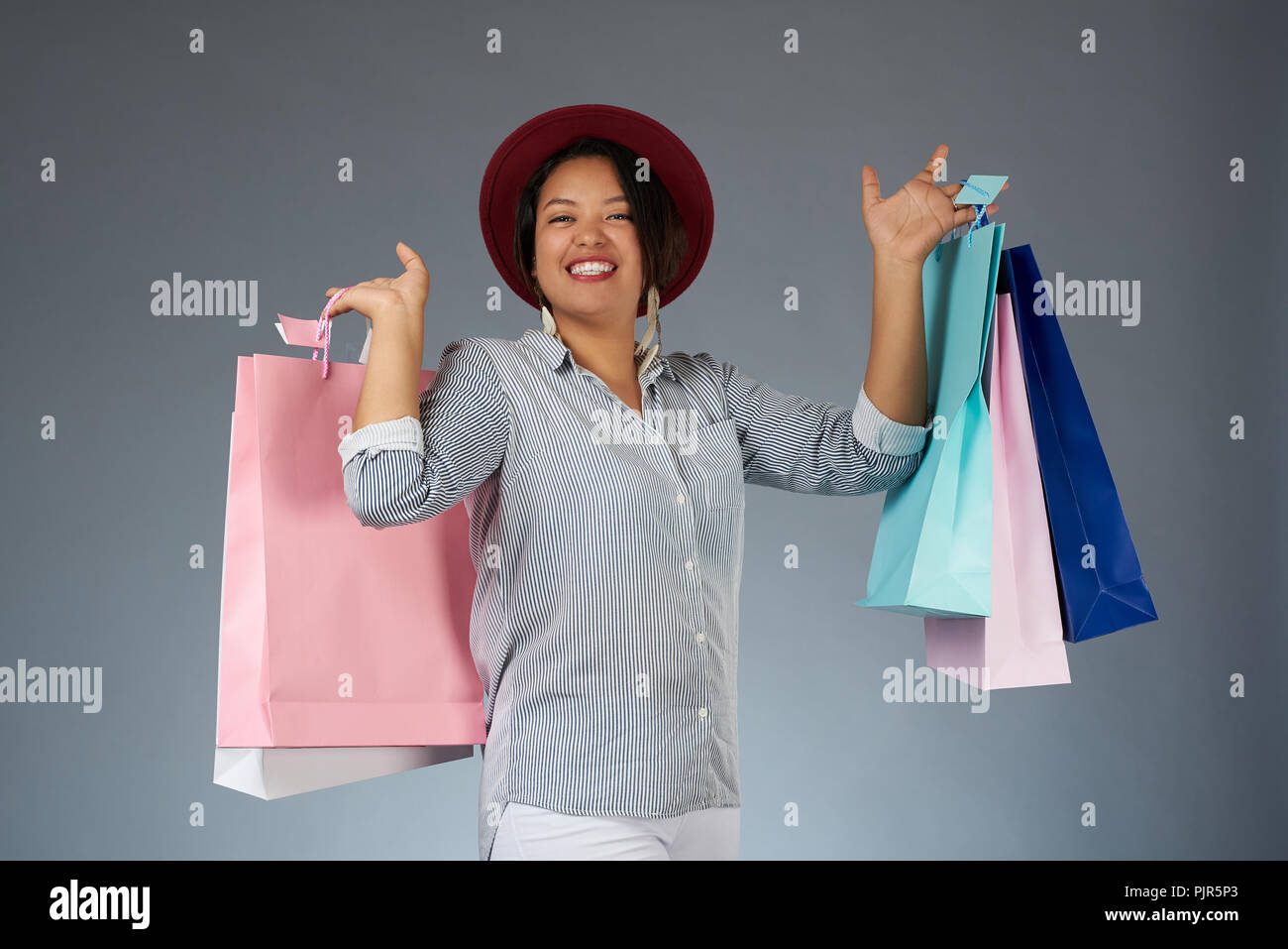 Shopping verkauf Thema. Junge lächelnde Frau mit bunten Taschen Stockfoto