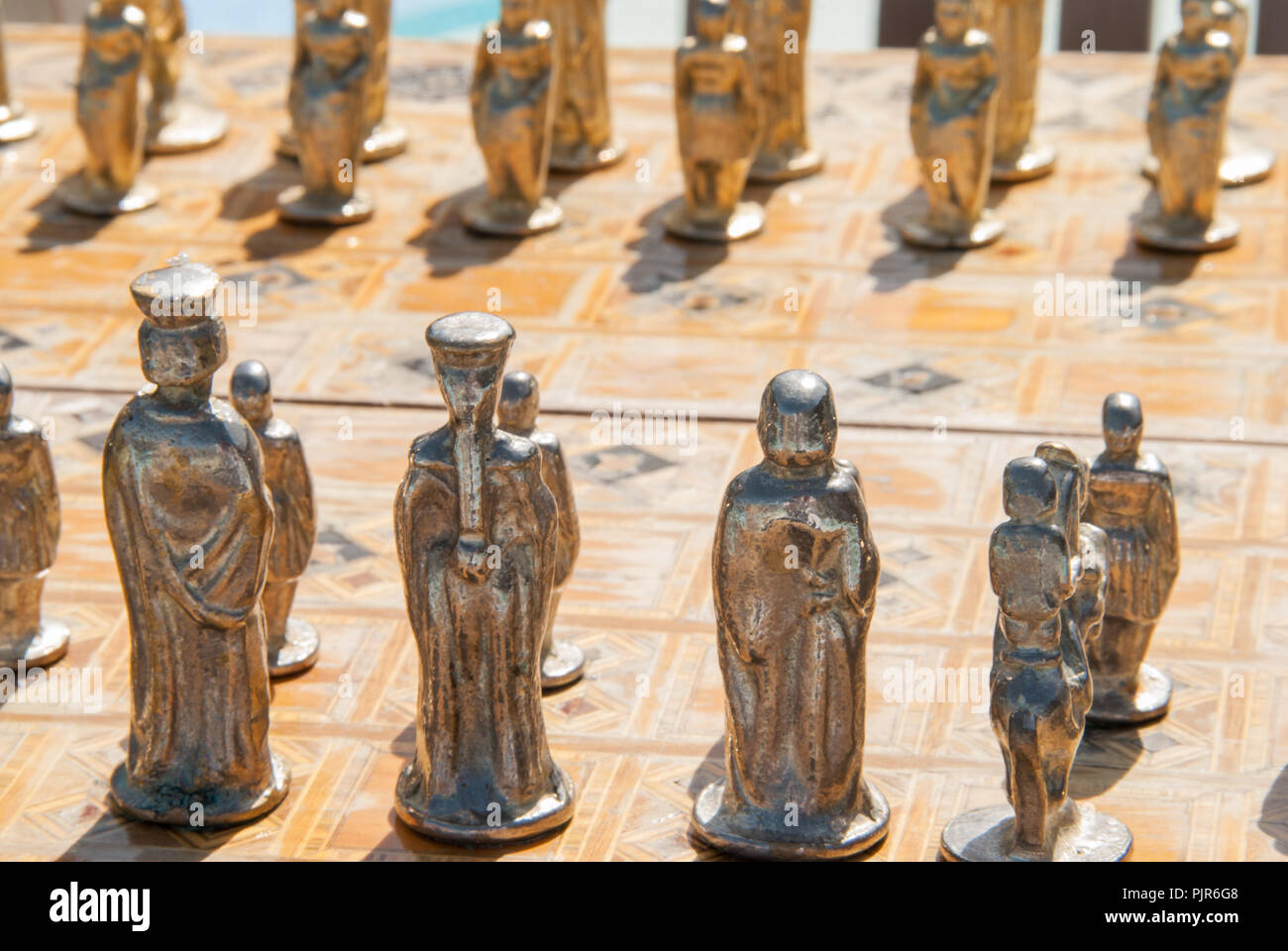 Vergoldete Schachfiguren auf eine Hand mit Intarsien aus italienischem Marmor, Schachbrett. Stockfoto