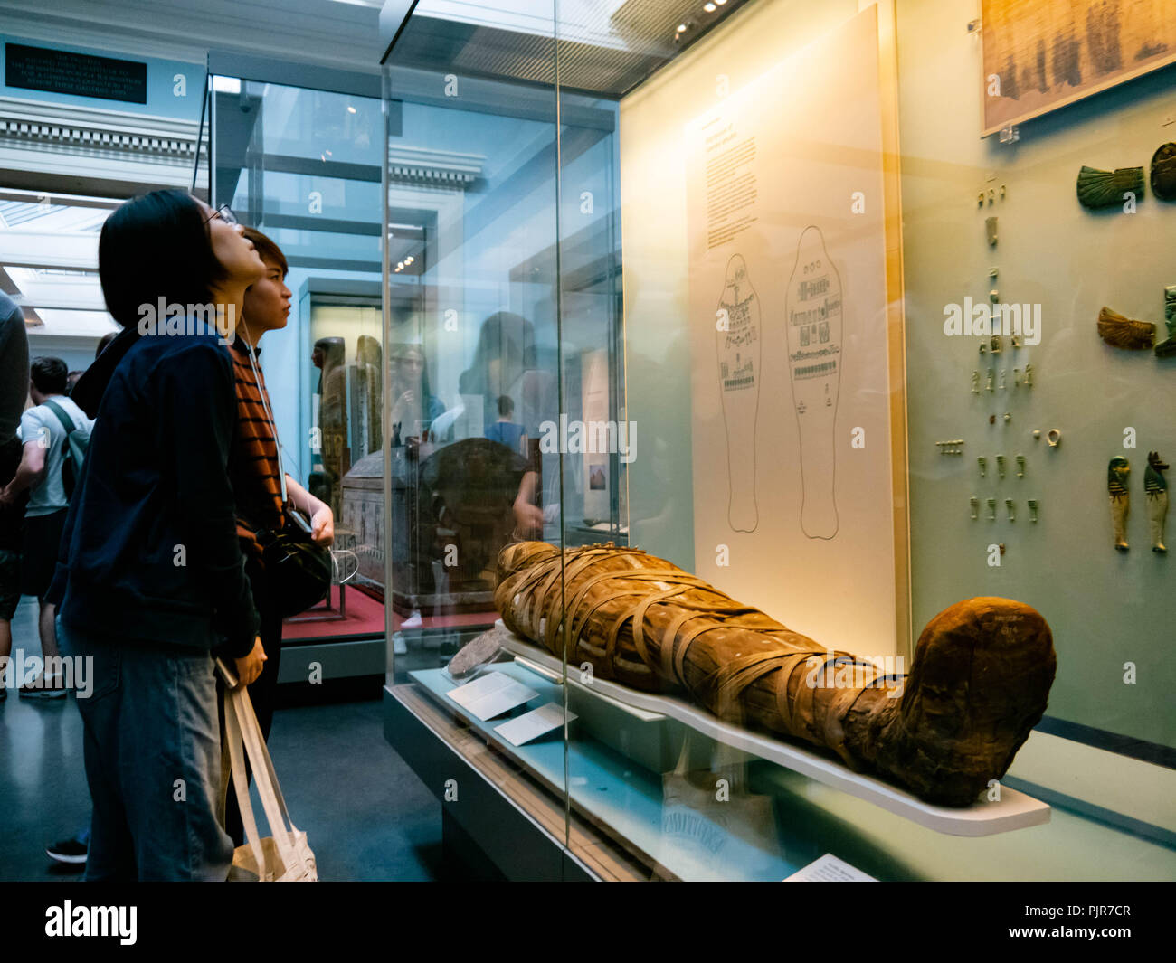 Besucher des British Museum in London, England, sehen sich eine Mumie aus der ägyptischen Sammlung an Stockfoto