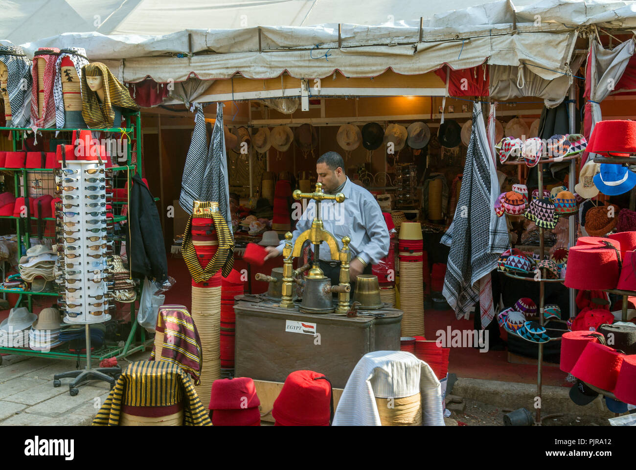 Kairo, Ägypten, 18. Februar 2017. Shop für Hüte, Fez oder tarbush und ägyptischen Kopfbedeckungen mit dem Verkäufer, Hüte und die Maschine vor zu machen Stockfoto