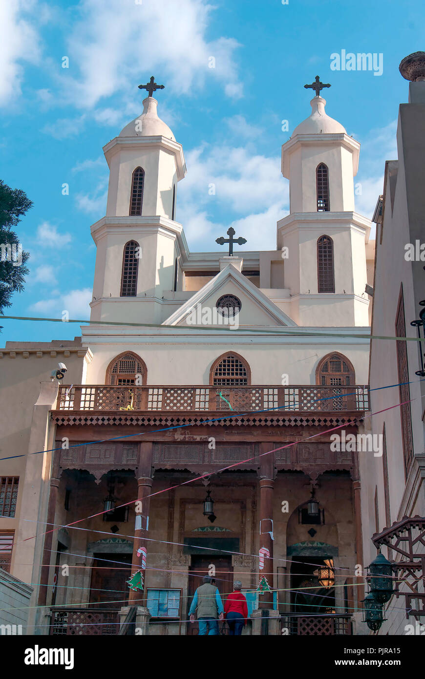 Fassade eines kleinen Koptische Kirche mit einem hölzernen Spalte Veranda im christlichen Viertel von Kairo mit zwei Personen eingeben Stockfoto