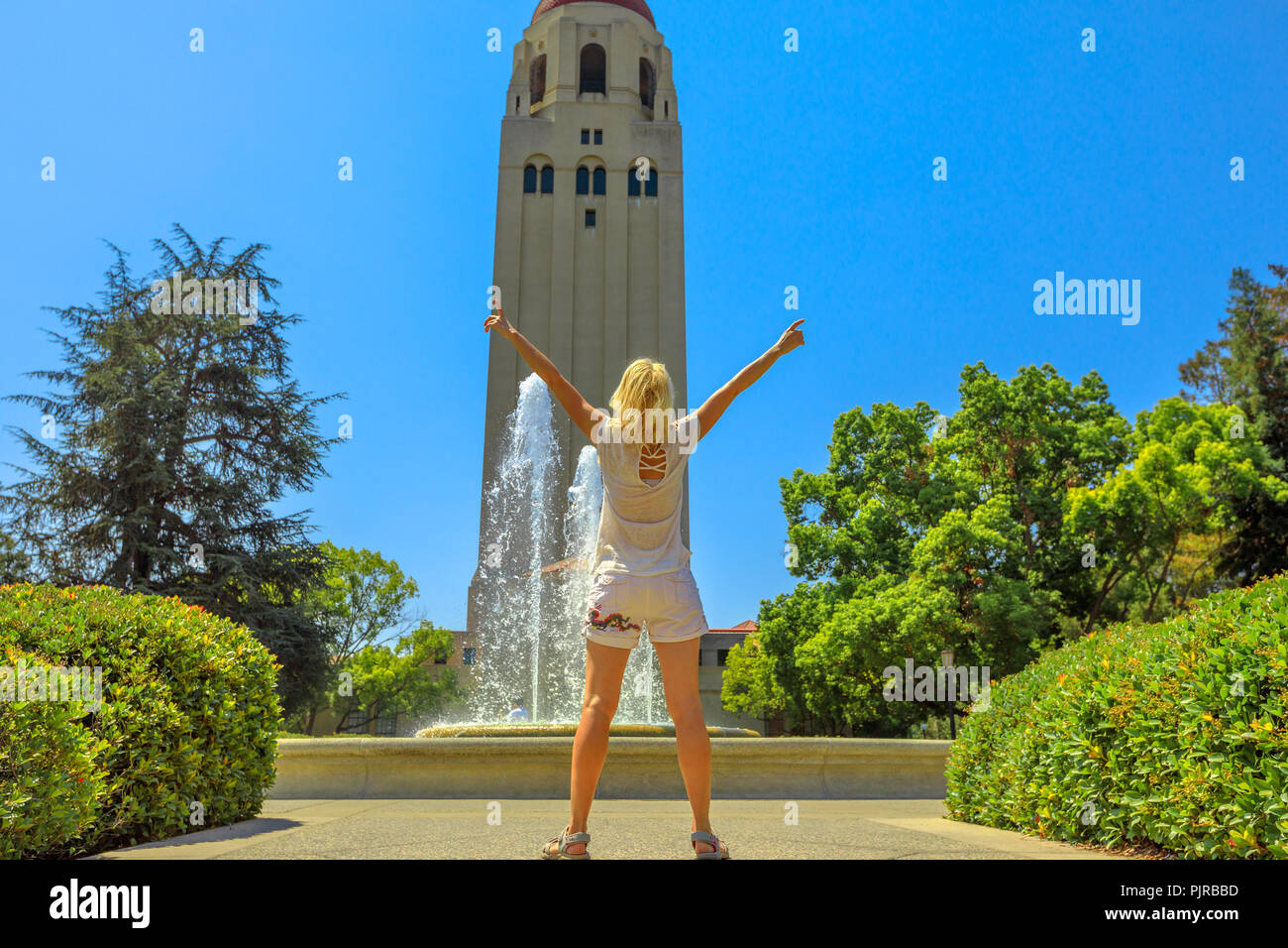 Junge glücklich kaukasische Mädchen mit erhobenen Armen genießt ihre Universität von Träumen in San Francisco, Kalifornien. Stockfoto