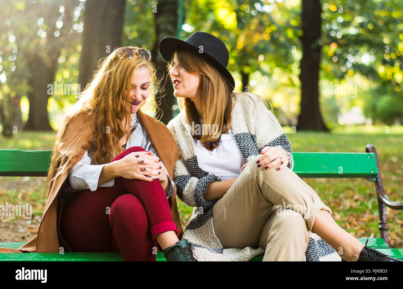 Weibliche Freunde klatschen in den Park an einem Herbsttag Stockfoto
