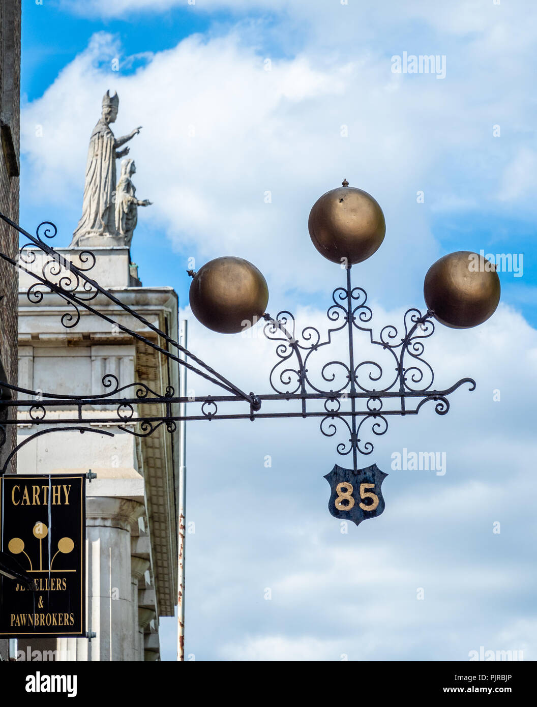 Der Bauer broker Zeichen außerhalb ein Restaurant in Dublin in Irland mit dem symbolischen Drei goldene Kugeln oberhalb der Straße mit St Marys Kathedrale Portico über Stockfoto