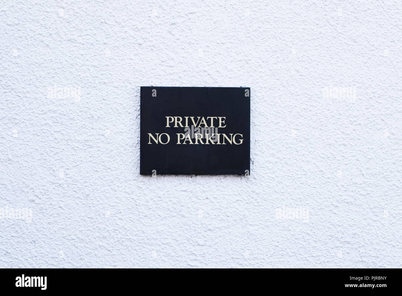 Kein Parkplatz privat minimal schwarze Zeichen auf leere weiße Wand Stockfoto