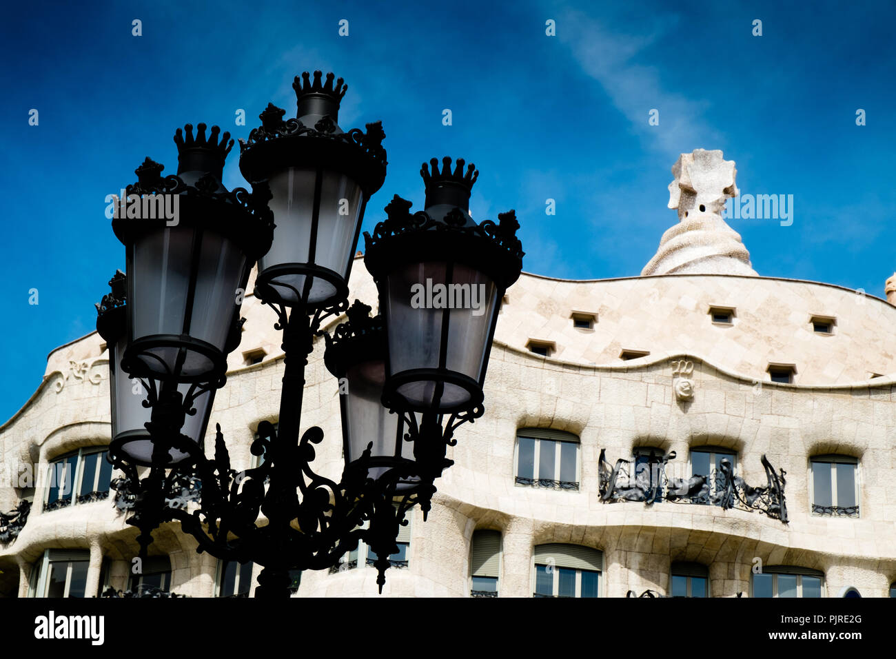 Casa Mila oder La pedrara mit Straßenlaterne im Vordergrund in Barcelona Stockfoto