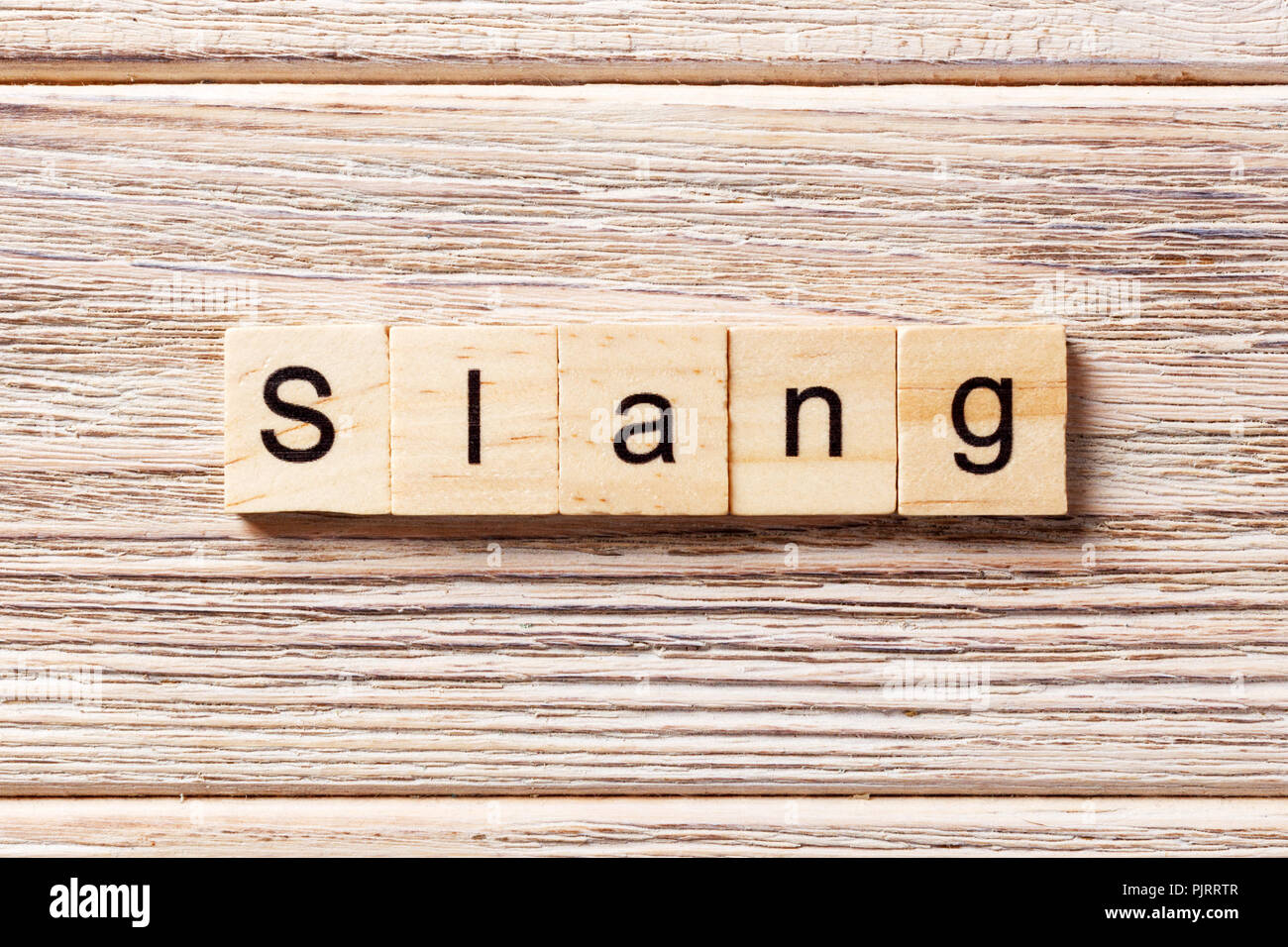 Slang Word auf Holz Block geschrieben. slang Text auf Tisch, Konzept. Stockfoto