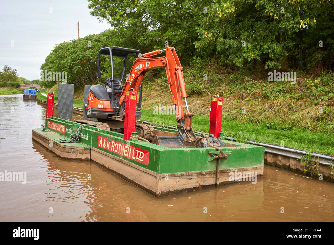 Mini Bagger an Bord eines Kanal Lastkahn für Baggerarbeiten in der Nähe von Nantwich auf dem Shropshire Union Canal eingestellt Stockfoto