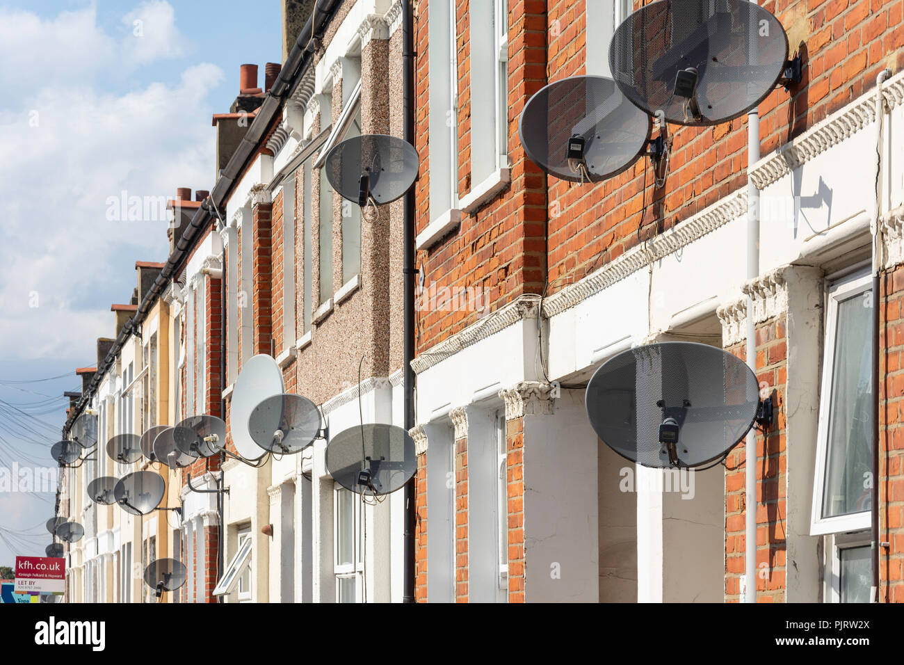 Satellitenschüsseln an der Vorderseite der Reihenhäuser, Cilbey Straße, Tooting, Londoner Stadtteil Wandsworth, Greater London, England, Vereinigtes Königreich Stockfoto