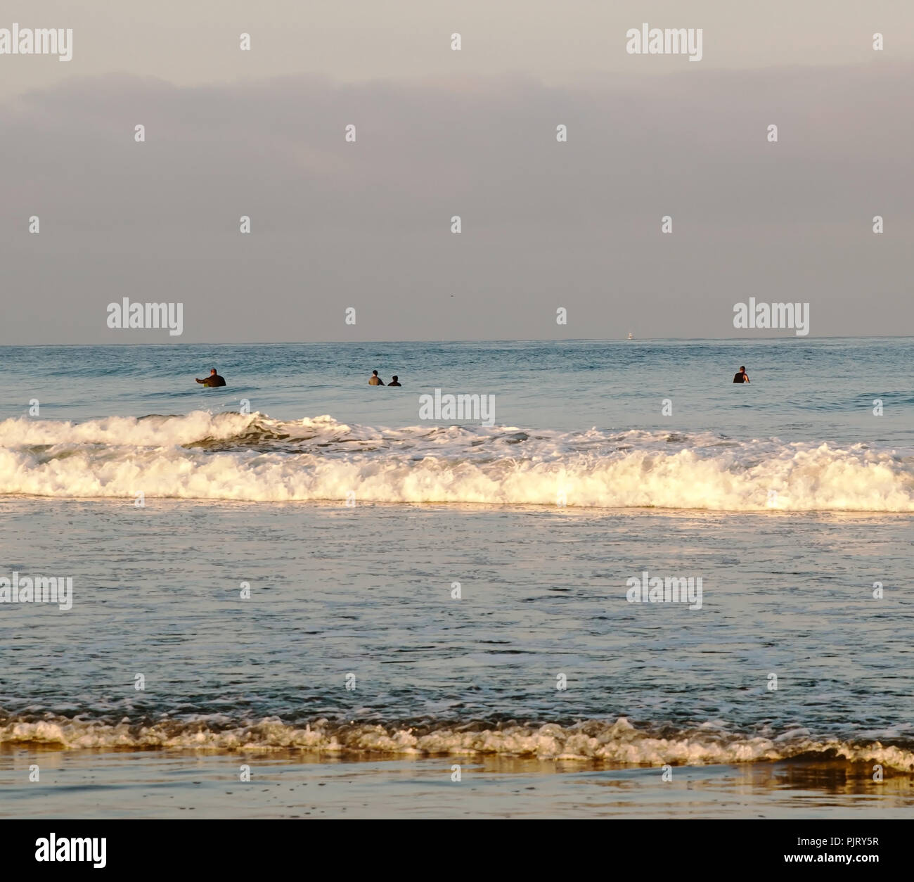 Drei Surfern im Wasser für eine Welle im Pazifischen Ozean vor der Strand an der USMC bast Camp Pendleton im südlichen Kalifornien, USA warten Stockfoto