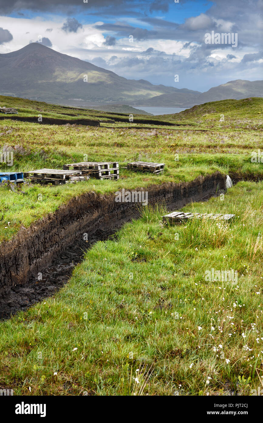 Trench cut in tiefe Torf der Moore in der Nähe von Feuchtgebieten Drinan auf der Isle of Skye Schottland mit Loch Slap und Beinn Na Caillich Berg Stockfoto