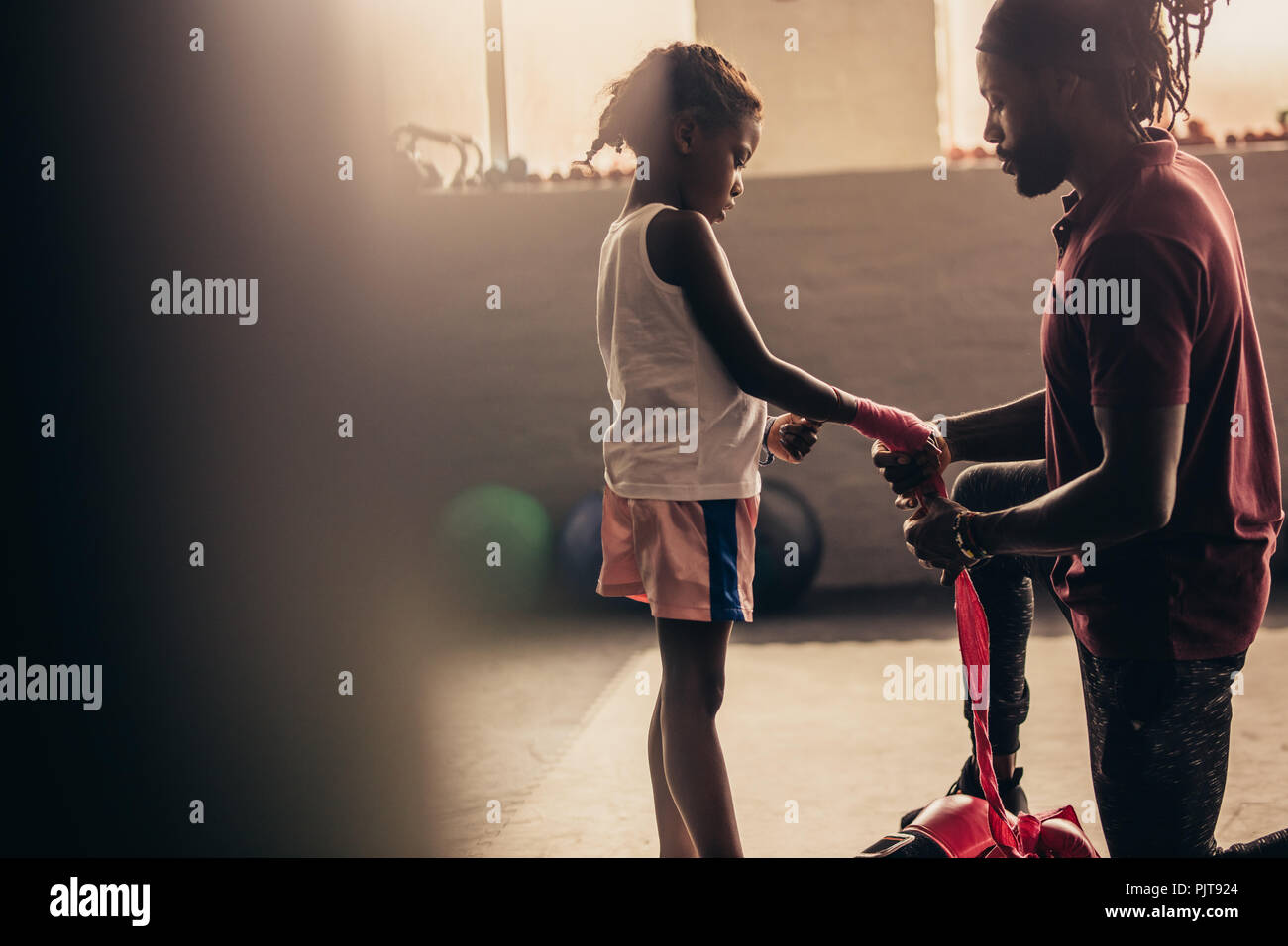 Boxing Trainer putting Verband an den Händen eines kid Boxer. Boxen kid wickelt seine Hände vor dem Tragen von Boxhandschuhen. Stockfoto