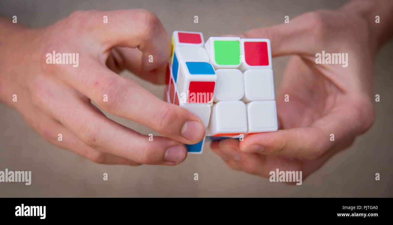 Nahaufnahme der Hände, die versuchen, die Rubik's Cube zu lösen Stockfoto